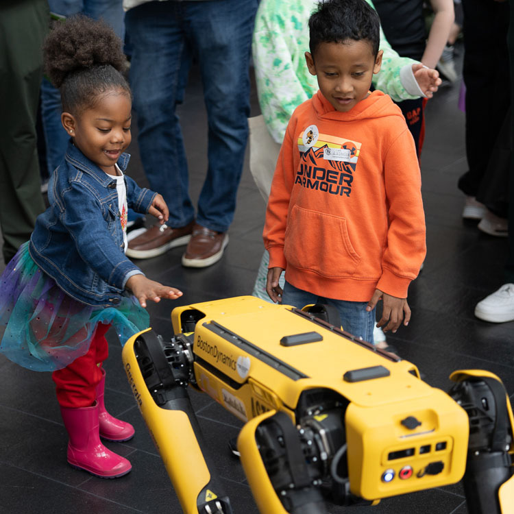 Young children with a robot at the Atlanta Science Festival.